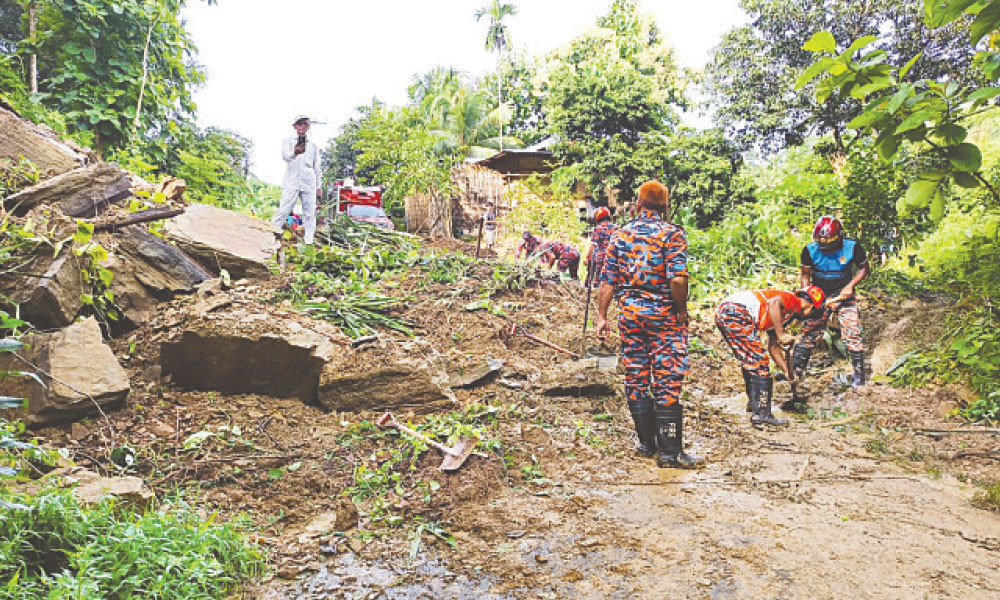 রাস্তা থেকে মাটি সরানোর কাজ করছেন ফায়ার সার্ভিসের কর্মীরা
