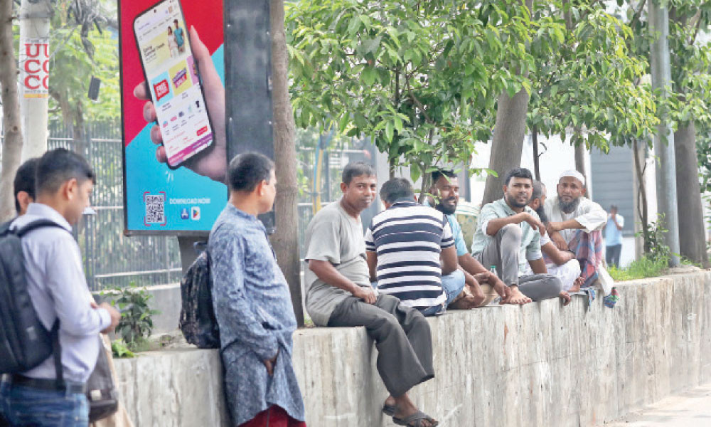 প্রচণ্ড গরমে একটু স্বস্তি পেতে সড়ক বিভাজকের গাছের ছায়ায় বিশ্রাম