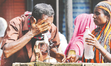 প্রচণ্ড গরমের দুপুরে একটু স্বস্তির আশায় হাত-মুখে পানি দিচ্ছেন শ্রমজীবী মানুষ