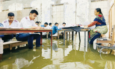 জলাবদ্ধতায় বেঞ্চে পা তুলে পরীক্ষা দিচ্ছে এসএসসি পরীক্ষার্থীরা