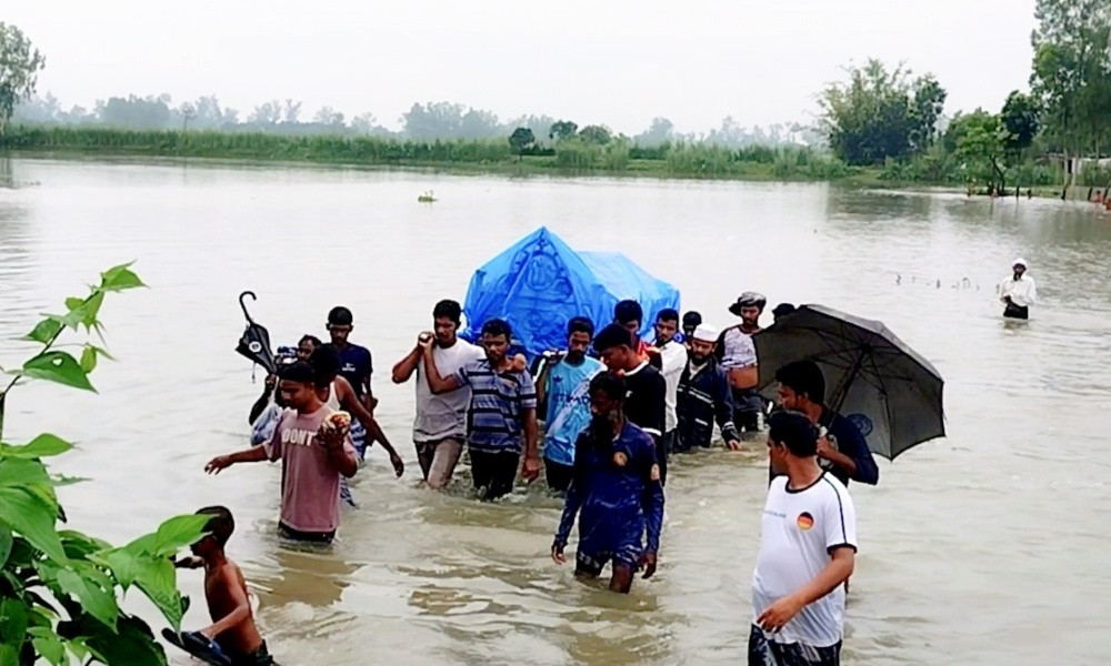 শেষ বিদায়েও দুর্ভোগ, গলা সমান পানি পেরিয়ে লাশ কবরস্থানে নিলেন স্বজনরা