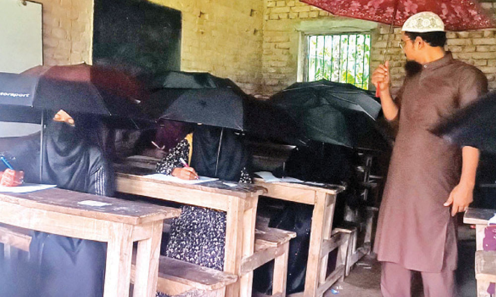এক হাতে ছাতা অন্য হাতে কলম শিক্ষার্থীদের